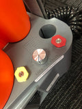 Close-up of a valve with red and yellow knobs on a textured surface